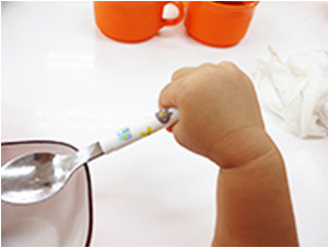 写真：0歳～1歳8ヶ月頃のスプーンを持つ手